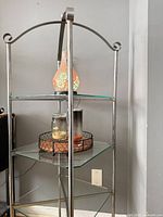 Full view of metal frame display shelf with glass shelves