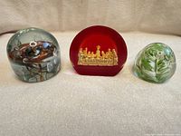 Group view of three glass paperweights