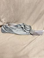 Full view of gray breathable mesh sling carrier laid flat