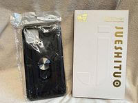 Front view of sealed black case beside branded box