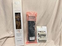 Lot overview: boxed brown hair extension, bagged black hair extension, carded silver clips