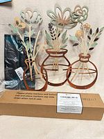 All three lot items together: boxed calendar, metal floral art, packaged accessories