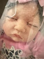Close-up of doll face in plastic wrap