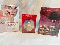 Three sealed oracle card decks standing upright