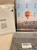 Three sealed photo albums: white, hot-air-balloon print, black zebra