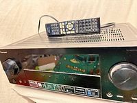 Front and top view of Pioneer VSX-823-K receiver with remote resting on top