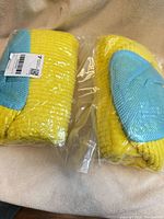 Two sealed yellow and blue shoe wash bags side by side
