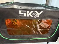 Front view showing SKy logo, orange window and black/green exterior