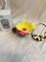 Lot overview showing boxed dispenser, bagged popsicle holders, beaded necklace