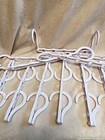 Group of white plastic cascading hangers displayed flat