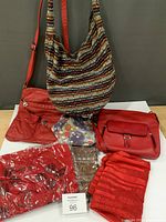 All items laid out: two red handbags, striped tote, drawstring pouch, three packaged/new scarves