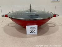 Bodum red cast iron wok with glass lid and rack visible