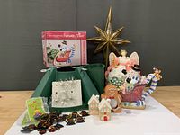 Group shot showing all items: tree stand, star topper, angel figure, sleigh teapot with box, gingerbread pieces, silver tinsel toppers, plastic angel ornaments