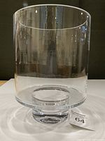Front view of clear crystal barrel vase upright on table