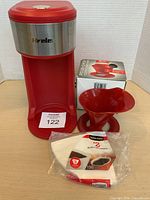 Front view of red Hrele coffee maker, Melitta dripper, sealed filters