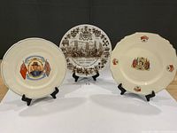 Front view of all three commemorative plates on stands