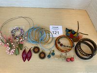 All jewelry items laid out including bangles, bracelets, earrings and feather piece