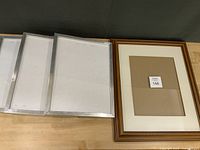 Three silver metal IKEA frames and one wood frame front view