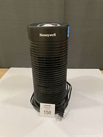 Full front view of black Honeywell tower air purifier with power cord