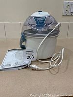 Ice cream maker assembled with cord and booklet visible