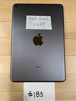 Rear view showing space grey back, Apple logo, taped label noting model and capacity
