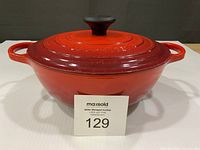 Front view of Le Creuset Dutch oven showing cherry red exterior and side handles