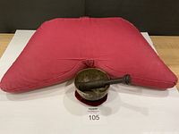 Red crescent cushion behind brass singing bowl set