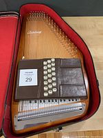 Autoharp inside red-lined case, strings and chord bars visible