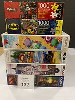 Stack of five puzzle boxes showing titles and 1000-piece count