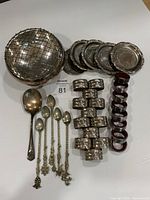 All items grouped for overview: rose bowl with grid, spoons, napkin rings, coasters