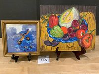 Both artworks on stands: bead art left, still-life painting right