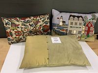 All three cushions together: floral tapestry, lighthouse tapestry, sage green faux suede/silk