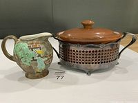 Casserole in metal stand beside Radford pitcher