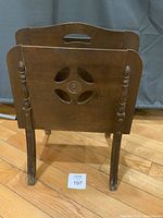 Front view showing cut-out design, turned posts, flared legs