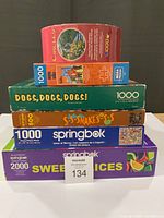 Stacked view of six puzzle boxes showing titles and piece counts