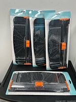 Four sealed paper cutters displayed together