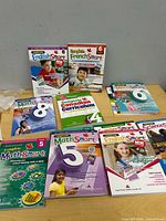 Top view of nine sealed curriculum workbooks for Grades 5, 6 and 8 displayed on table