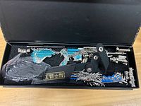 Top view of box interior showing metal M416 model, sling strap and bagged stand parts