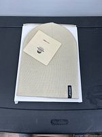 Beige ribbed knit beanie on box with tag