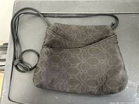 Front view of Maruca black fabric handbag showing pattern and pocket