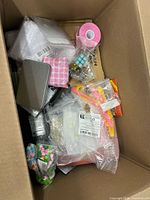 Overview of assorted items including tape roll, plastic bags, tin, beads, dice, tweezers and findings