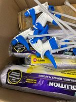 Box containing multiple blue-white trigger sprayers and purple-packaged Evolution roller covers