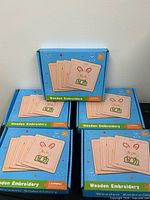Front view of five boxed wooden embroidery kits