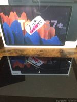 Front view of Asus tablet; Samsung Tab S7+ box visible in background