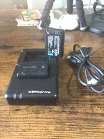 Charger with one battery inserted, USB cable visible