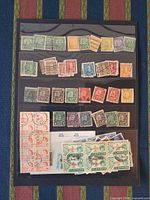 All stamps displayed on black album page showing singles and blocks