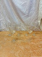 Front view of six clear ribbed wine glasses on table