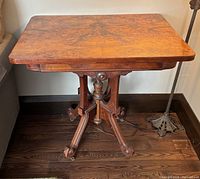 Full view of Eastlake walnut side table showing pedestal base and casters