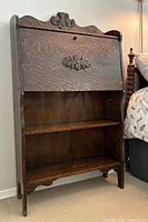 front view closed showing carved crest and panel