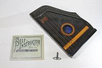 Zither with instruction booklet and tuning key laid out